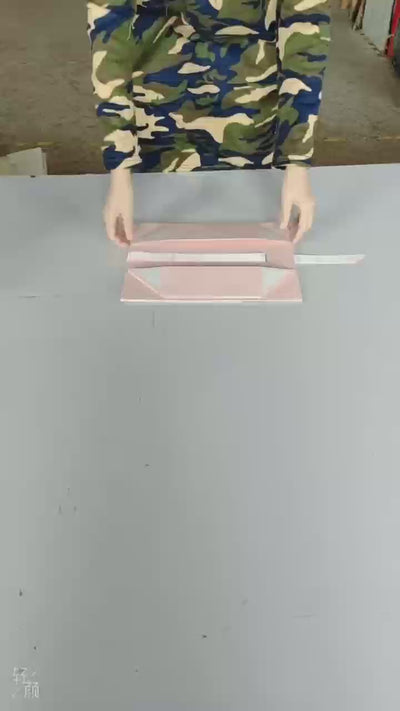 Pink handled collapsible gift box being assembled and opened